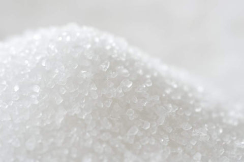 Eritritol - Ce este, beneficii, moduri de utilizare si contraindicatii ale indulcitorului natural_O imagine detaliata cu cristale de eritritol, evidentiind textura si aspectul lor similar cu zaharul