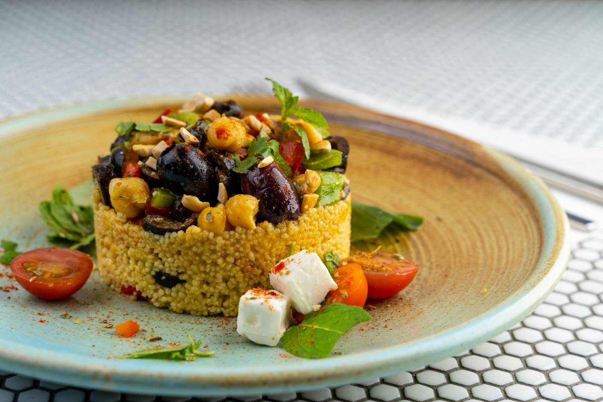 2._Cuscus_cum_poti_personaliza_reteta_clasica_pentru_a_obtine_variante_delicioase_cuscus_farfurie_masline_rosii_branza_b4a2be90-d7e4-48ed-b50b-111f25b41d78