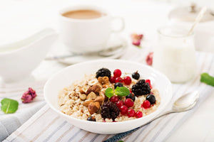 2. Porridge de ovaz - castron alb, porridge, fructe si alune de padure, ceasca cu cafea